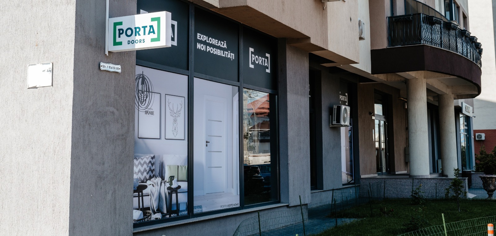 Magazinul de uși Pro Casa Doors din Bacău văzut din stradă, pe Str. 1 Mai bl. 60, cu firma PORTA DOORS deasupra vitrinei