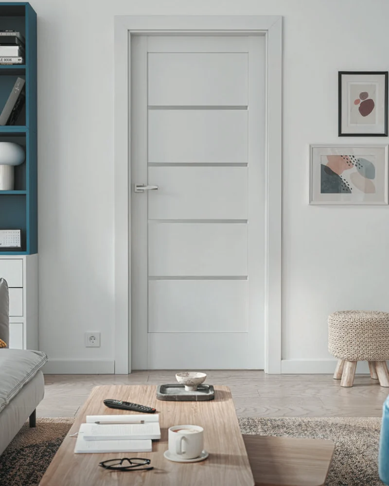 Ușă Porta Verte Home G.4 albă, cu patru inserții orizontale de sticlă, într-un living cu bibliotecă albastră