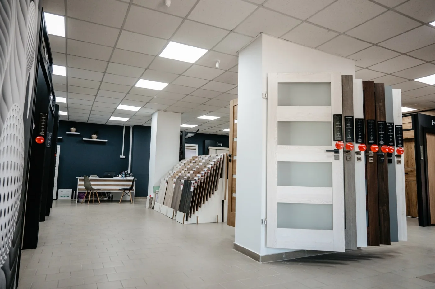 Rastelul cu foi de ușă și fâșii de finisaj din showroom-ul de uși din Bacău, fiecare cu mânerul montat pe ea